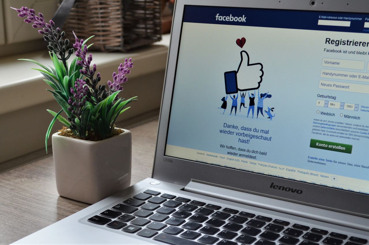 services-04 A Lenovo laptop displaying Facebook login beside a lavender plant indoors.
